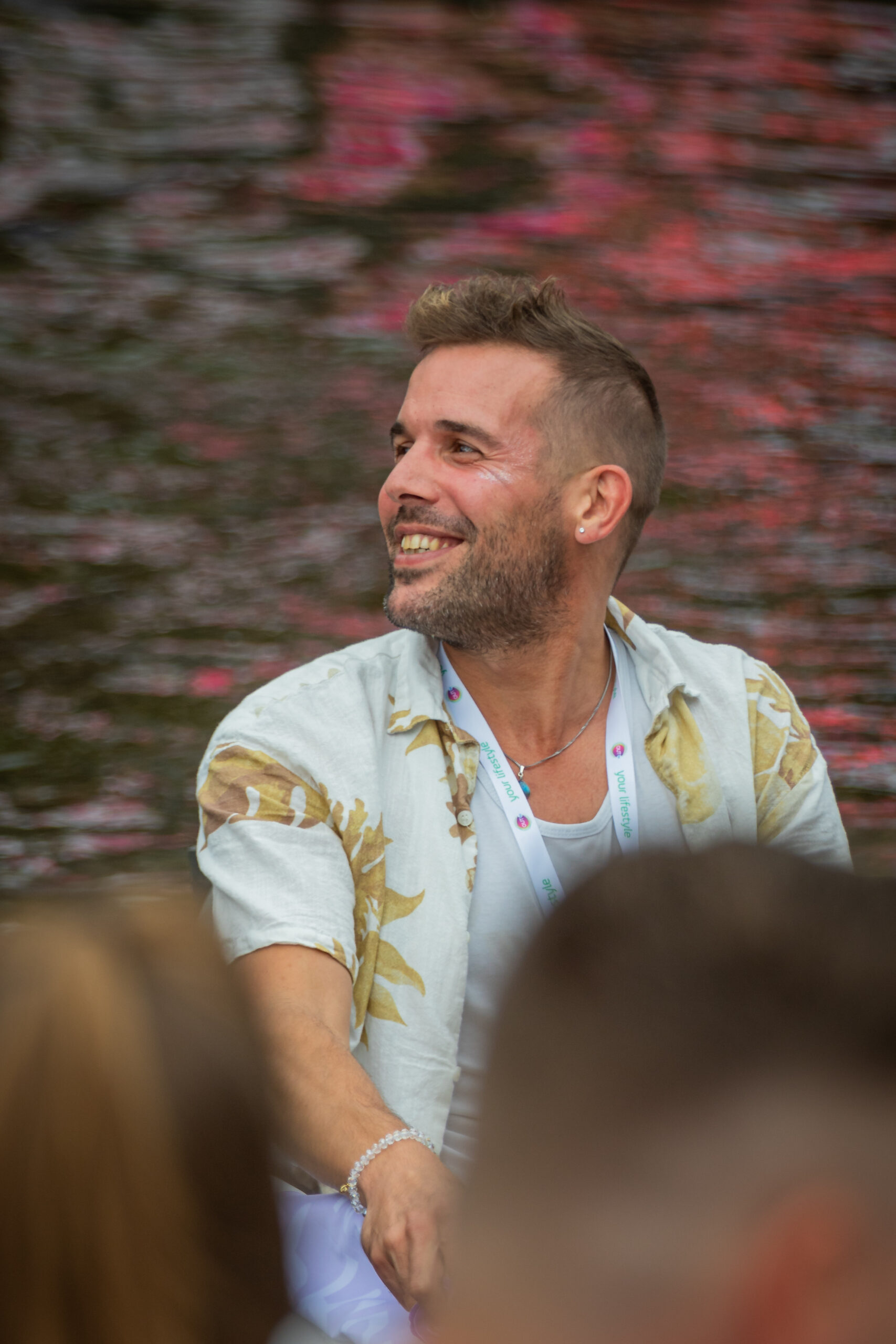 Lars smiling on a boat during Pride Amsterdam 2023, celebrating the canal parade as one of the organisers in Lars’ inspiring journey.