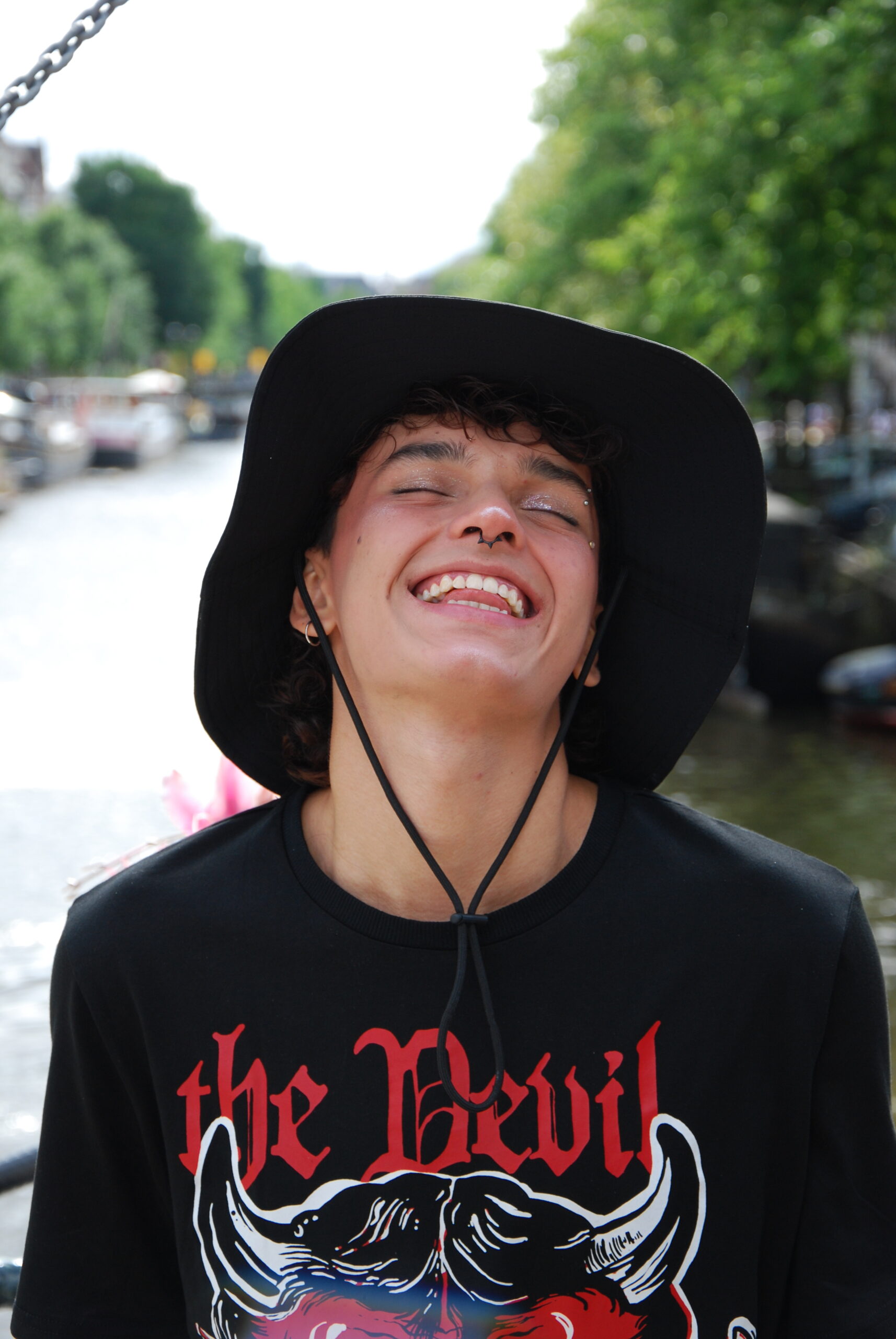 Sebas wearing makeup for a photoshoot by the beautiful canals of Amsterdam, showcasing his creative journey.